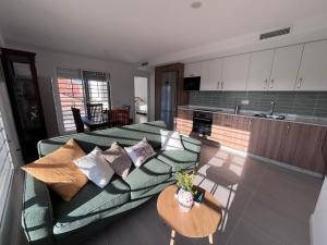 a living room with a green couch and a kitchen at Eco Espacio Camaleón Verde 2 in Cartagena