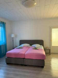 a bedroom with a pink bed in a room at Caroline in Leoben