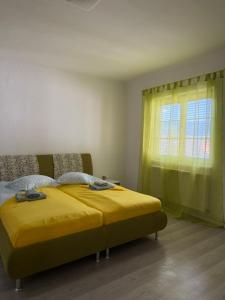 a bedroom with a yellow bed and a window at Caroline in Leoben +1 photo