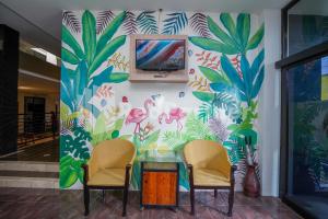 two chairs and a table in front of a wall with a mural at Griya Borobudur Malang Syariah RedPartner in Blimbing