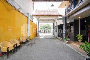 an empty alley with chairs and a building at Griya Borobudur Malang Syariah RedPartner in Blimbing