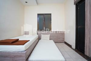 a bedroom with two beds and a window at Griya Borobudur Malang Syariah RedPartner in Blimbing