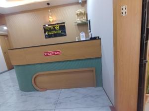 a front desk of a restaurant with a sign on it at Hotel Harmony Inn in Ahmedabad