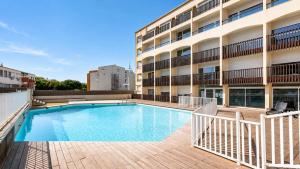 a swimming pool in front of a building at Le St Clair N208 ST2 in Agde