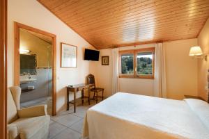 a bedroom with a bed and a desk and a window at Ball de Bastons in Avinyonet +15 photos