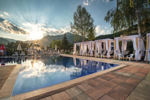a pool with a bunch of white tents and chairs at Spa Hotel Persenk in Devin