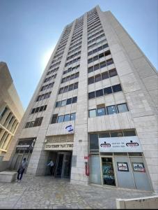 a tall building with a man standing in front of it at City tower 16 floor in Jerusalem