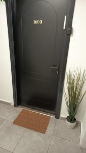 a black door with a welcome mat in front of it at City tower 16 floor in Jerusalem