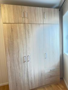 a large closet with wooden cabinets in a room at Cozy 2-Bedroom Apartment in Kristiansand