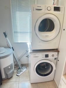 a washing machine and a washer in a room at Cozy 2-Bedroom Apartment in Kristiansand +3 photos