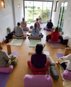 a group of people sitting in a room practicing yoga at Eco Espacio Camaleón Verde 2 in Cartagena