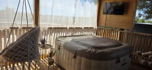 a porch with a hammock and a tv and a window at Mobile home Bokun sriće in Drage +38 photos