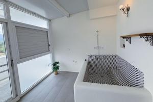 a white bathroom with a tub and a large window at Village Villa B&B in Zhuqi +152 photos
