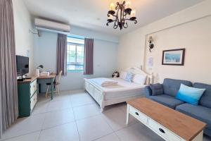 a bedroom with a bed and a couch and a desk at Village Villa B&B in Zhuqi
