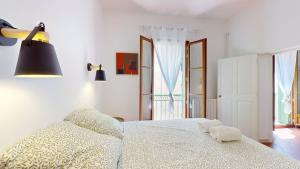 a bedroom with a white bed with two towels on it at L'atelier de la rue Mailly in Perpignan