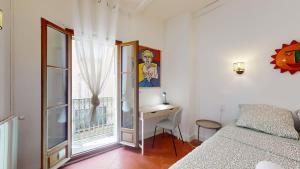 a bedroom with a desk and a bed and a window at L'atelier de la rue Mailly in Perpignan
