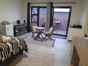 a bedroom with a bed and a table and chairs at Lavender Suite in Gansbaai +3 photos