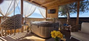 a screened in porch with a soaking tub and chairs at Mobile home Bokun sriće in Drage