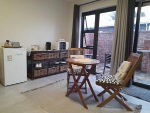 a kitchen with a table and chairs and a refrigerator at Lavender Suite in Gansbaai