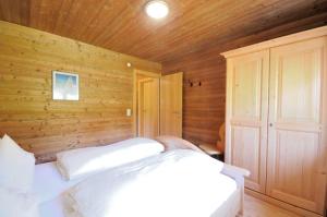 a bedroom with two beds and a wooden wall at Bungalow Müller in Brand