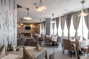 a restaurant with white tables and chairs and chandeliers at Spa Hotel Persenk in Devin +44 photos