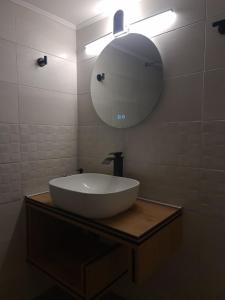 a bathroom with a large white sink and a mirror at Rhódia & Sun by Booking Kottas in Ixia