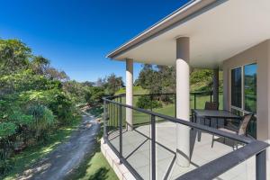 a balcony with a table and chairs on a house at Surfside in East Ballina