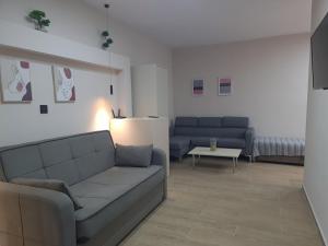 a living room with two blue couches and a table at Rhódia & Sun by Booking Kottas in Ixia +23 photos