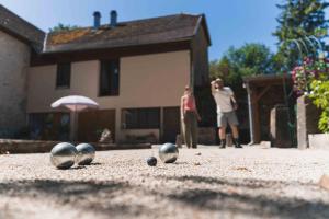 two people standing in a yard with balls on the ground at Les Greniers in Myon