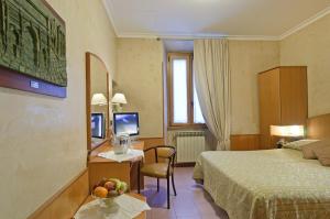 una camera d'albergo con letto e scrivania con cesto di frutta di Hotel Museum a Roma