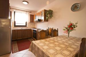 a kitchen with a table with a vase of flowers on it at Apartment Ivka in Poreč