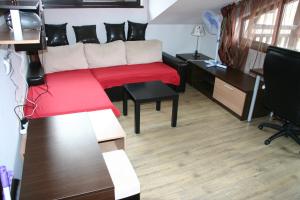 a living room with a couch and a red blanket at Alexander 3327 in Bansko