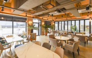 a restaurant with tables and chairs and windows at 계룡 호텔 스테이318 in Gyeryong