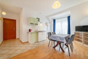 a kitchen and dining room with a table and chairs at Willa Promyk in Jastarnia