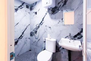 a bathroom with a white toilet and a sink at Graha Martadinata Syariah Mitra RedDoorz in Tasikmalaya