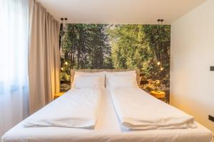 two beds in a bedroom with a painting on the wall at Casa Lipa in Horní Maršov