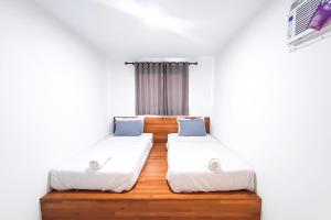 a room with two beds and a window at Graha Martadinata Syariah Mitra RedDoorz in Tasikmalaya
