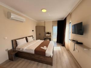 a bedroom with a bed and a flat screen tv at Rena Grand Residence & Suit in Trabzon