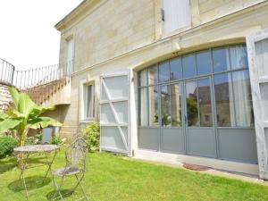 two chairs and a table in front of a house at La Pénesais in Beaumont-en-Véron