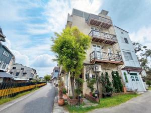 a tall building with a tree in front of it at Village Villa B&B in Zhuqi