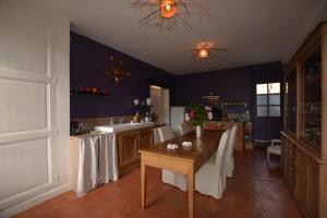 a kitchen with a table with white table cloths on it at La Pénesais in Beaumont-en-Véron
