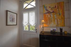 a room with a door and a window and a dresser at La Pénesais in Beaumont-en-Véron +28 photos