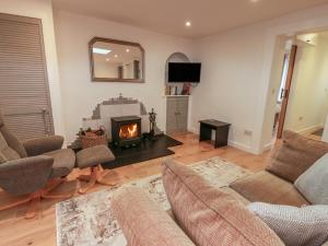 a living room with a couch and a fireplace at Rosalin Cottage in Irvine