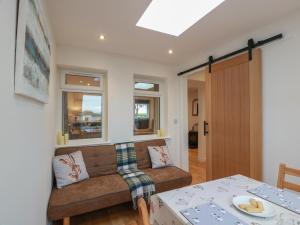 a living room with a couch and a table at Rosalin Cottage in Irvine