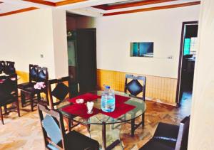 ein Esszimmer mit einem Glastisch und Stühlen in der Unterkunft New Islamabad Hotel in Islamabad