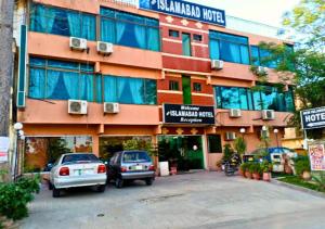 ein Gebäude, vor dem Autos parken in der Unterkunft New Islamabad Hotel in Islamabad