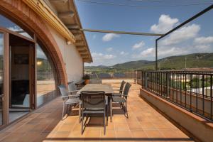 a patio with a table and chairs on a balcony at Ball de Diables in Sant Pau dʼOrdal