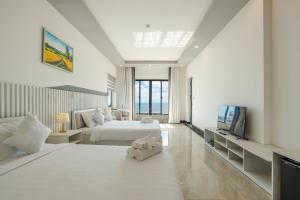 a white bedroom with a bed and a tv at Casa De Sol Resort - Wuwei Retreat in Phú Quốc +55 photos