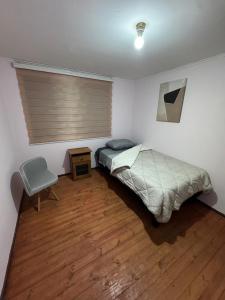 a bedroom with a bed and a chair in it at Hostel Campus Lircay in Talca +4 photos