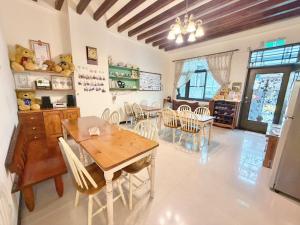 a dining room with a wooden table and chairs at Village Villa B&B in Zhuqi